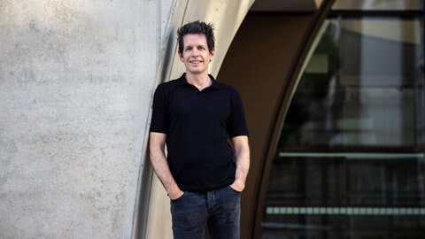 Martin Andree, Medienwissenschaftler, lehnt mit der Schulter an einer Betonwand.