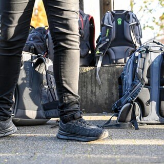 Ein Schüler steht auf einem Pausenhof vor Schulranzen. An Schulen steigt die Anzahl an rechtsextremen Vorfällen.