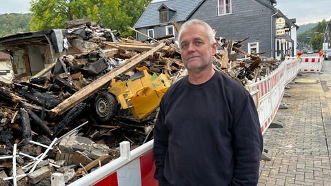 Dirk Kosbab steht vor den Überresten eines Hauses in Daaden. Nach dessen Explosion hatte er einen Jugendlichen aus den Trümmern geholt.