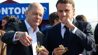 Bundeskanzler Olaf Scholz (SPD) und Frankreichs Präsident Emmanuel Macron (rechts) essen im Oktober 2023 in Blankenese ein Fischbrötchen. Gemeinsames Speisen ist eines der ältesten Instrumente der Diplomatie, um Verständigung und Kooperation zu fördern.