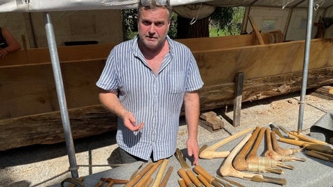 Archäologe Wolfgang Lobisser mit Werkzeugen aus der Bronzezeit. Im Pfahlbaumuseum in Unteruhldingen wollen Experimentalarchäologen ein sogenanntes Plankenboot nachbauen, eine Weiterentwicklung des Einbaums.