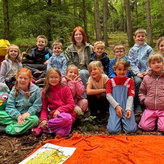 Laura Krauß mit den Schülern der 1c der Grundschule Mackenbach. Im Wald haben die Kinder viel Spaß. 