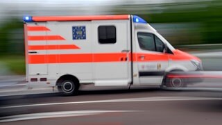Ein Krankenwagen fährt mit Blaulicht über eine Straße. (Sujetbild)