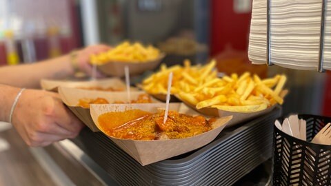 Im Imbiss "Curry 76" in Karlsruhe sind Currywurst mit Pommes der Renner.