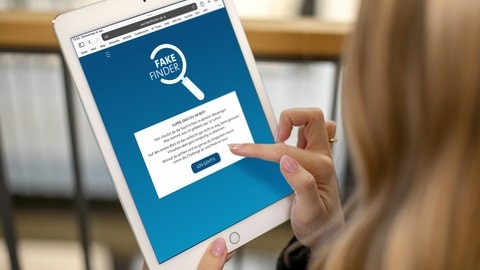 Eine Frau bedient die App Fakefinder des SWR auf einem Tablet.
