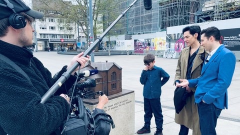 Bei den Dreharbeiten: Shane Mayer mit seiner Familie besuchen das Mahnmal auf dem Platz der alten Synagoge in Freiburg. Die Synagoge hat die Familie Mayer einst mitgegründet. Sie wurde in der Reichpogromnacht 1938 von den Nationalsozialisten angezündet.