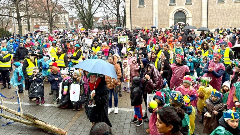 Bunte Faschingsmenge feiert im Regen vor dem Rathaus in Wasseralfingen.