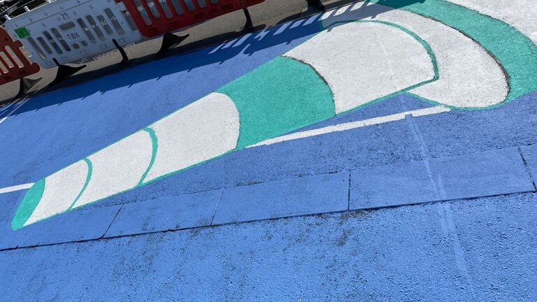 Entlang des Hafens in Konstanz sind bunte Bilder aufgemalt, man sieht sportliche Motive wie Bälle.