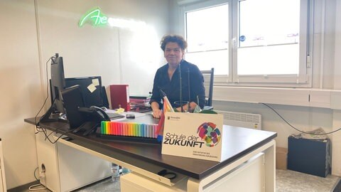 Nina Pfeil, Schulleiterin des Are-Gymnasiums, sitzt an ihrem Schreibtisch. Statt am alten Standort in Bad Neuenahr-Ahrweiler besuchen die fast 900 Schülerinnen und Schüler jetzt eine Container-Schule in der Grafschaft - etwa acht Kilometer entfernt und höher gelegen.