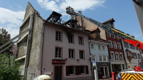 EInsatzkräfte der Feuerwehr auf der Drehleiter bei Nachlöscharbeiten in der Innenstadt in Villingen. 