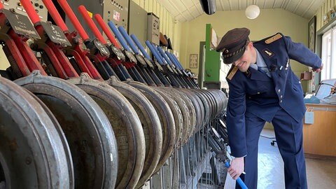 Matthias Langen von den Eisenbahnfreunden steht in historischer Uniform an den Weichenhebeln im bereits renovierten Stellwerk 1 in Calw. 