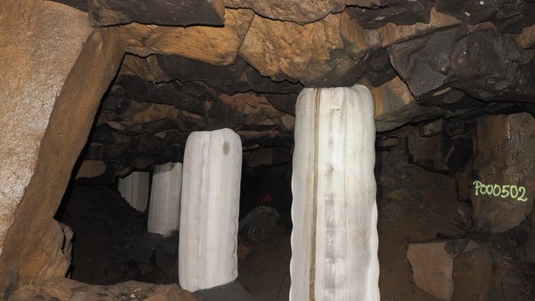Unterirdische Hohlräume unter Mayen und dick verpackte Stützpfeiler, die den Bereich sichern, aus dem Basaltblöcke aus der Decke gebrochen sind.  