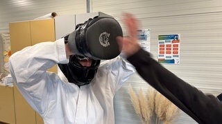 Beim Karatekurs schlägt eine Hand in einen Hand-Schoner