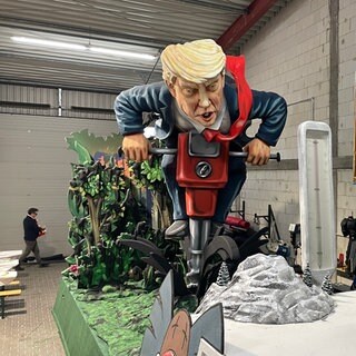Motivwagen für den Rosenmontagszug 2025 in Mainz: US-Präsident Donald Trump sucht mit einem großen Bohrer nach Bodenschätzen. 