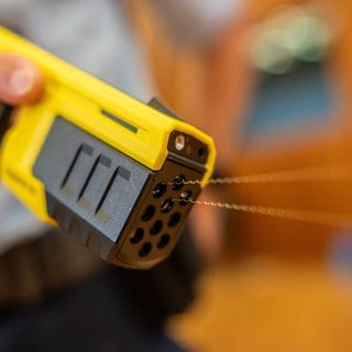 Ein Polizist der Bundespolizei führt einen Taser 10 vor. Mit der Pistole werden Pfeile an Drähten verschossen, über deren elektrische Impulse Angreifer "stillgelegt" werden können. 