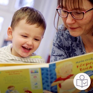 Kitas in Deutschland haben zu wenige Mitarbeiter. Das heißt: Nicht alle Kinder können richtig betreut werden. Das sagen Fach·leute von der Bertelsmann Stiftung. Das Bild zeigt ein Kleinkind. Eine Betreuerin liest dem Kind vor. Rechts das SWR Logo für Leichte Sprache. 