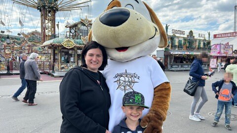Mirjam Proch und ihr Sohn Luca machen ein Foto mit Maskottchen Timi Hope.