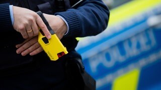 Ein Polizeibeamter demonstriert einen Taser.