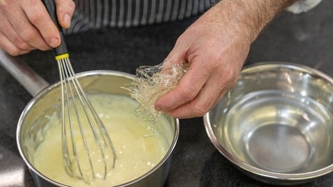 Das Herz des Bienenstichs: In den aufgekochten Vanille-Pudding wird die eingeweichte Gelatine eingerührt. Wenn die Masse erkaltet ist, nur noch die geschlagene Sahne leicht unterheben - fertig!