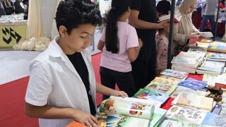 Ein Junge liest ein Buch am Chinesischen Pavillon der 40. Internationalen Buchmesse in Tunis