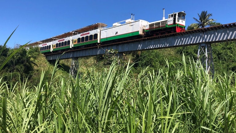 Zug auf der letzten der vier langen geländerlosen Eisenbahnbrücken bei Christchurch