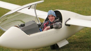 Alex sitzt im Cockpit seines Segelflugzeugs, mit dem er später abgestürzt ist.  SWR1 Neuanfang: Alex überlebt den Absturz mit dem Segelflieger – die Sehnsucht nach Höhe und Weite bleibt