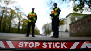 Polizisten stehen hinter einem sogenannten Stop Stick - einer modernen Art von Nagelsperre