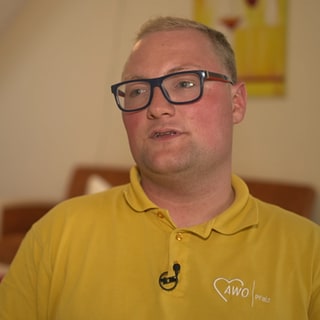 Junge Pflegkraft sitzt in einem Seniorenheim