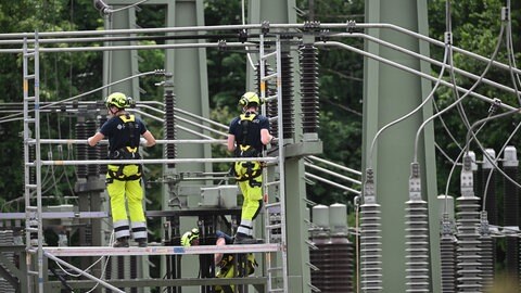 Mitarbeiter von FairNetz arbeiten auf dem Gelände eines Umspannwerks, in dem es in der Nacht gebrannt hatte.