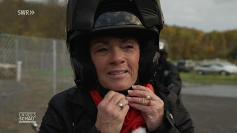Sonja Faber-Schrecklein zieht sich einen Motoradhelm an
