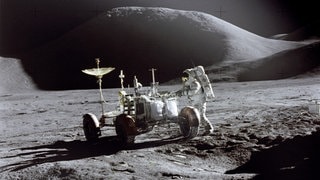 Der US-Astronaut James B. Irwin steht Ende Juli 1971, während der Apollo 15 Mission, auf dem Mond neben einem Mondfahrzeug.