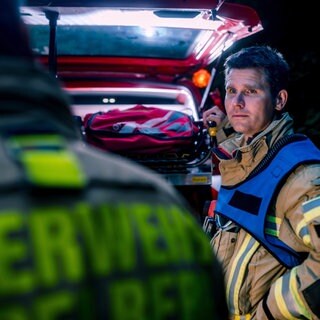 Berufsfeuerwehrmann vor Mehrzweckfahrzeug