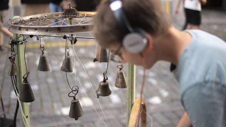 Ein Jugendlicher probiert die Klanginstallation "Orkestronia" aus, bei der Eroeffnung des 22. Buskers Festival, am Donnerstag, 7. August 2025, in Bern.