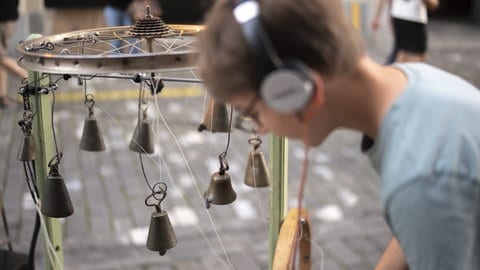 Ein Jugendlicher probiert die Klanginstallation "Orkestronia" aus, bei der Eroeffnung des 22. Buskers Festival, am Donnerstag, 7. August 2025, in Bern.