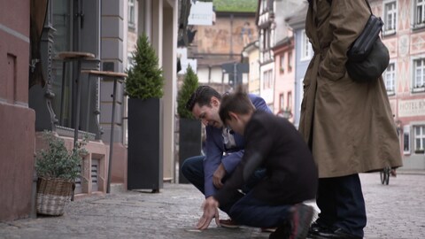 Shane Mayer mit seiner Familie am Stolperstein vor dem Elternhaus seins Großvaters Fred Mayer in der Herrenstraße in Freiburg