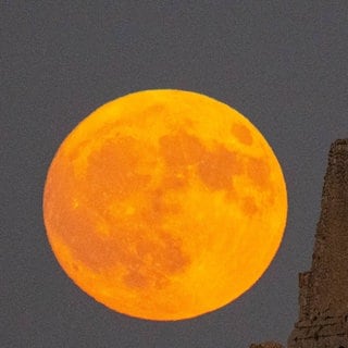 Störmond über einer Burg in Italien. Der Störmond ist der traditionelle Name für den Vollmond im August, besonders bekannt in Nordamerika. Auch auf dem Mond gibt es Jahreszeiten. Woran erkennt man die?