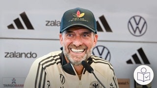 Fußball·bundes·trainer Jürgen Klopp bei einer Presse·konferenz. Klopp hat die Spieler für die National·mannschaft ausgewählt. Rechts das SWR Logo für Leichte Sprache.