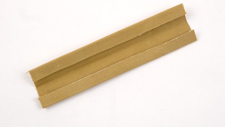 Für die Aufhängeschlaufe die Nahtzugaben der langen Seiten 1 cm nach links umbügeln. 