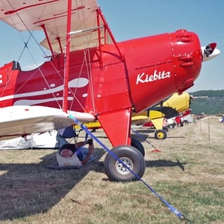 Ein roter Ultraleicht-Doppeldecker, ein sogenanntes Kiebitz-Flugzeug