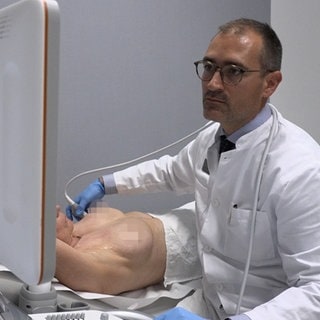Mit einem Ultraschallgerät untersucht der Ärztliche Direktor der Klinik für Frauenheilkunde an der Uniklinik Freiburg das Brustgewebe einer Patientin. 
