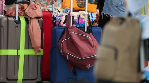 Symbolbild mehrerer Koffer, die am Flughafen stehen. Nach mehreren Straftaten wurde der Großteil einer syrischen Familie aus Stuttgart "kontrolliert ausgereist".