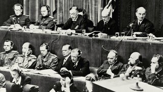 Urteilsverkündung am 1. Oktober 1946 beim Nürnberger Kriegsverbrecherprozeß vor dem alliierten Militärtribunal. Die Richterbank im Justizpalast während der Verlesung der Urteilsbegründung. V. l. n. r.: Wolchkow, Nikitschenko (UdSSR), Birkett, Lawrence (GB) und Biddle (USA)