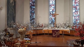 Eine Kirche ist festlich geschmückt mit vielen bemalten Ostereiern. In Gomadingen-Dapfen (Kreis Reutlingen) findet wieder der Ostereiermarkt statt.