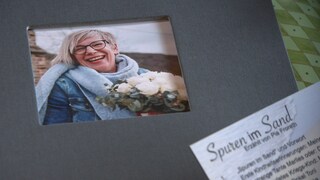 Graues Album mit Foto einer blonden Frau, die lacht.