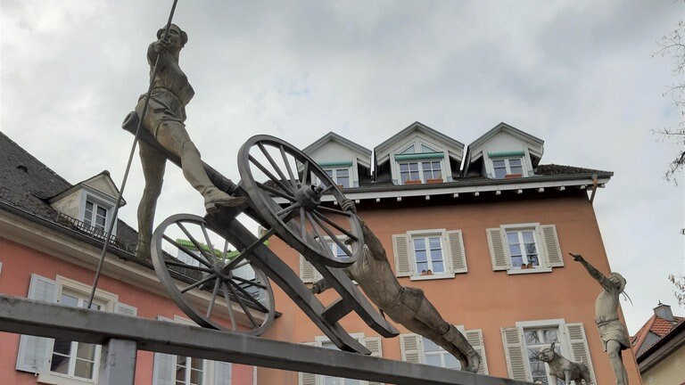 Badische Revolution 1848: Als "Feldherr" ist Friedrich Hecker ungeübt: Als Truppen des Deutschen Bundes ihm in Donaueschingen den Weg in den Norden versperren, muss er Richtung Südwesten abbiegen und gelangt ins Städtchen Schopfheim im Wiesental, wo er eine seiner feurigen Reden hält. Doch er überschätzt sein Charisma. Nur zwei Einheimische und ein Hund schließen sich seinen etwa 800 Mann an. – Auf dem Marktplatz in Schopfheim steht ein Denkmal. Vorne auf der Kanone ist Emma Herwegh zu sehen, hinten der Hund.