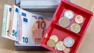 Geldscheine und Münzen: Viele Kommunen in RLP hoffen angesichts knapper Kasse auf Hilfe von der künftigen Landesregierung.