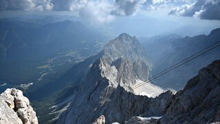 An der Zugspitze ist ein Mann aus Baden-Württemberg tödlich verunglückt. Laut Polizei stürzte er wahrscheinlich 50 Meter in die Tiefe. Das Bild zeigt den Blick vom Gipfel der Zugspitze ins Tal.