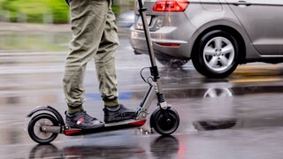 Ein Mann fährt mit einem E-Scooter auf der Straße (Symbolbil).
