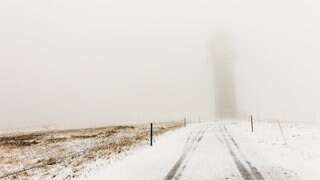 Schnee liegt auf dem Feldberg, der Feldbergturm ist schemenhaft durch den Nebel hindurch zu erkennen. Auf dem Feldberg gab es in der Nacht von Donnerstag und Freitag den ersten Schnee in diesem Jahr.