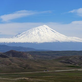 Schneebedeckte Berge unter klarem blauen Himmel mit weitläufiger Landschaft im Vordergrund, großer und kleiner Ararat